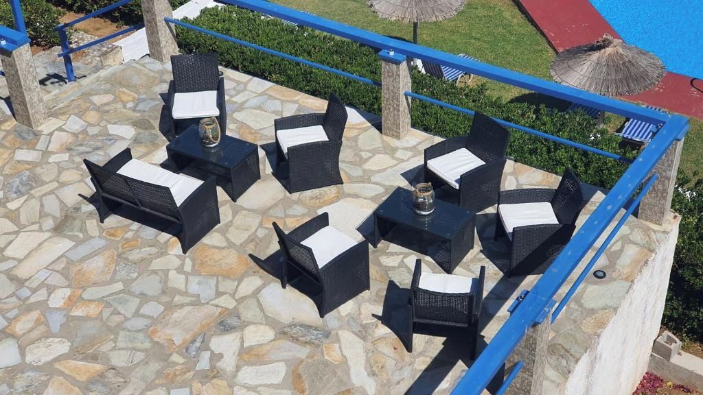 Outdoor seating with stone flooring and blue railings.