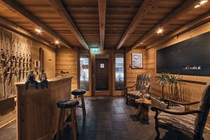 Un interior de madera con barra, decoración rústica y una gran pizarra con texto.