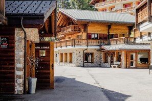 A wooden building with balconies, a stone facade, and a sign reading 'HOTEL L'ETABLE.' - Etable Des Crosets (Val d'Illiez)