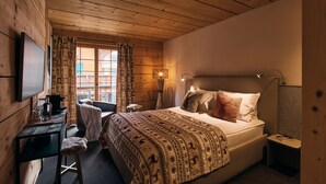 A wooden-paneled room with a bed, a desk, a chair, and a window with curtains. - Etable Des Crosets (Val d'Illiez)