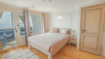 A bedroom with a bed, a nightstand, a wardrobe, and a sliding glass door leading to a balcony.