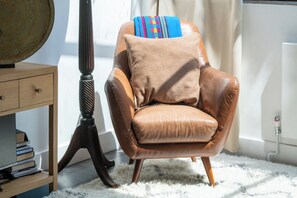 A brown leather armchair with a cushion and a colorful throw blanket. - Peaceful 2BDR Escape Near Primrose Hill (Greater London)