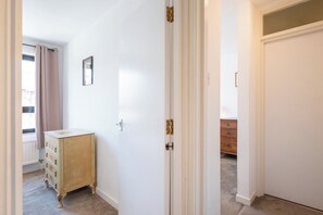 Ein Flur mit einer weißen Tür, einem Holzschrank und einem Heizkörper.