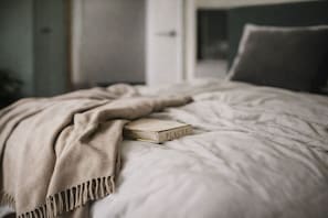 Ein Bett mit einer beigen Decke und einem Buch mit dem Titel 'PLACES'.