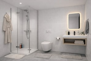 Ein modernes Badezimmer mit einer Glasdusche, Toilette, Waschbecken mit Spiegel und Handtuchhalter.