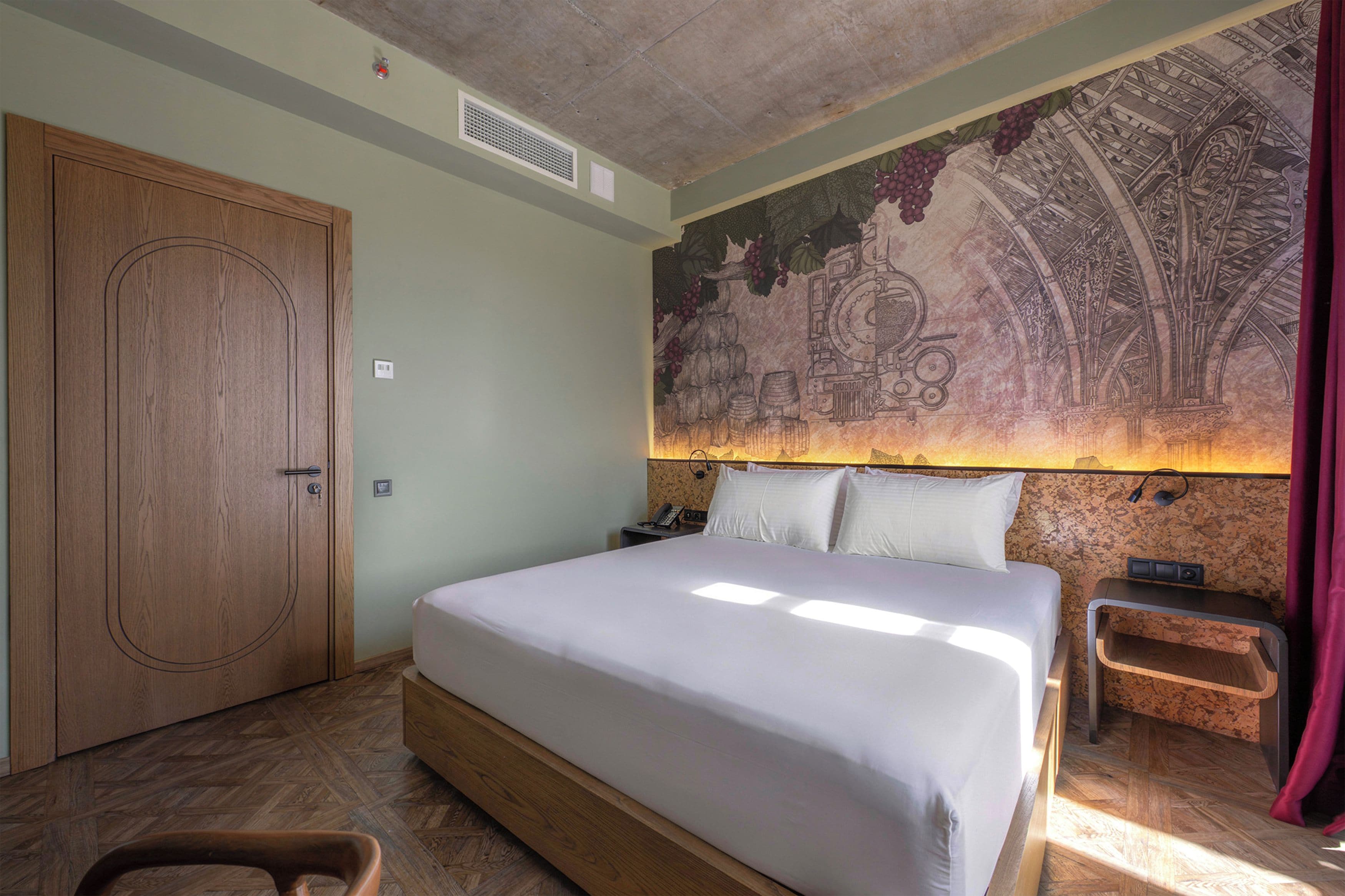 Un dormitorio con una cama grande, un armario de madera, una mesita de noche y un mural en la pared.
