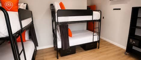 A bunk bed room with a desk and an air conditioning unit.