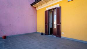 Ein Gebäude mit gelber Fassade, einer rosafarbenen Wand und einem gefliesten Boden.