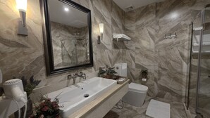 A bathroom with a marble wall, a large mirror, a sink, a shower, and a hairdryer. - Le Cannes, A Recall Luxe Hotel, Chiang Mai (Chiang Mai)