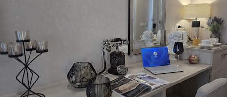 Un escritorio moderno con una computadora portátil, una copa de vino y una revista.