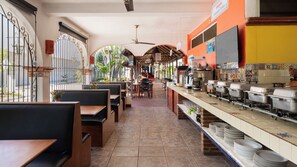 Een restaurant met terras, een buffet en uitzicht op de straat.
