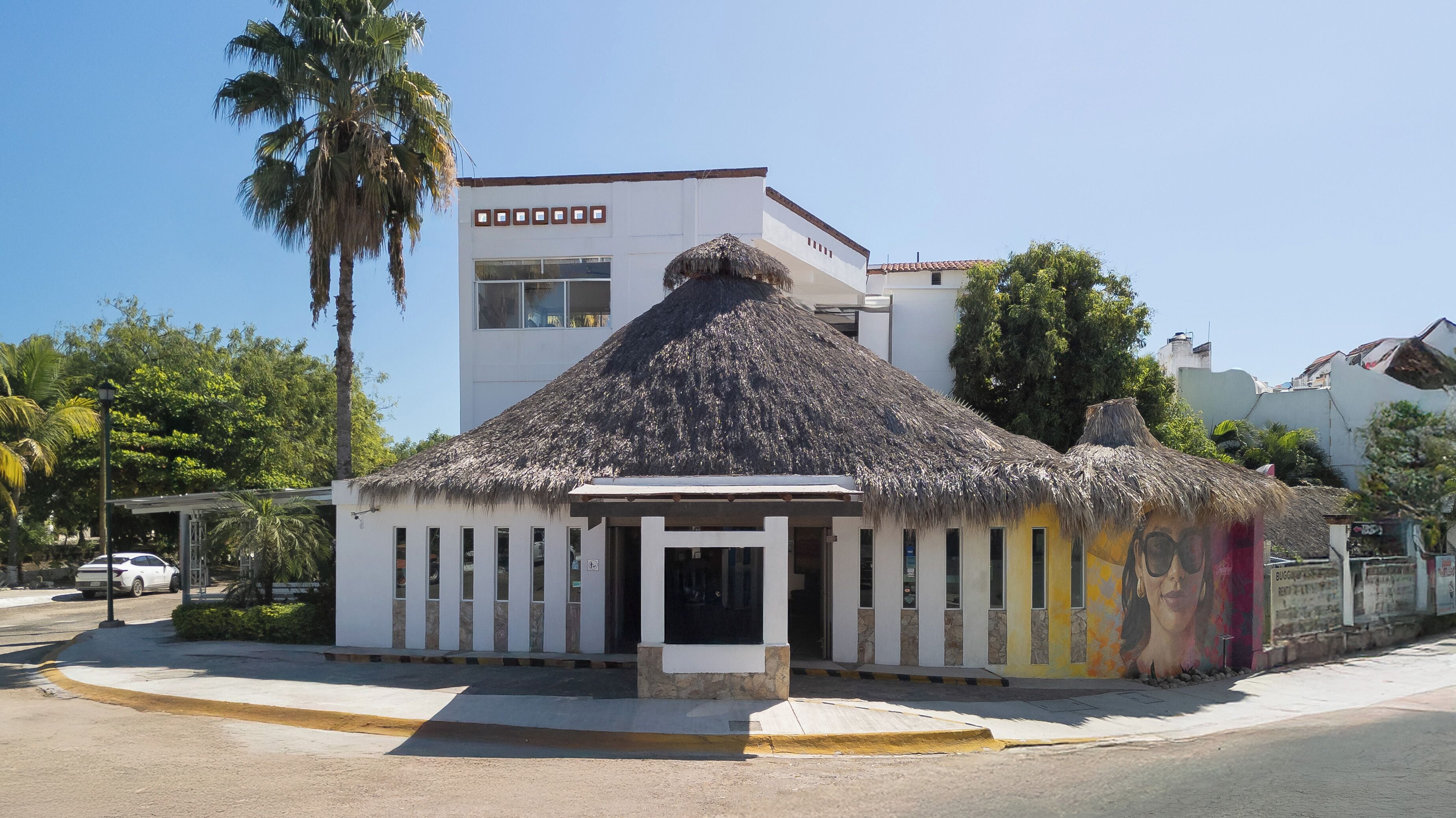 A building with a thatched roof, a white facade, and a modern design.