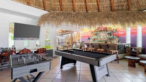 A pool table, foosball table, and bar area with a tropical theme. - Hotel Casa Chahue (Santa María Huatulco)
