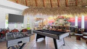 A pool table, foosball table, and bar area with a tropical theme. - Hotel Casa Chahue (Santa María Huatulco)
