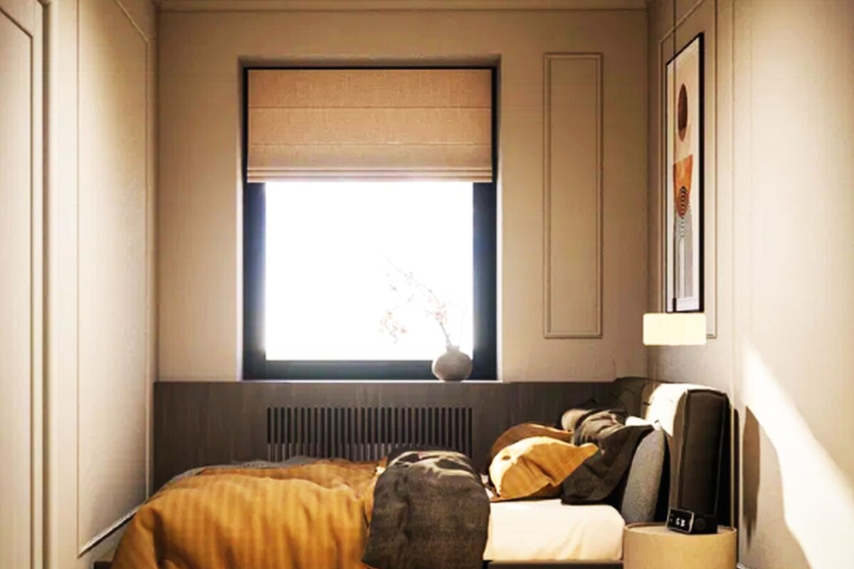A bedroom with a bed, a window with a view, a radiator, and a bedside table.