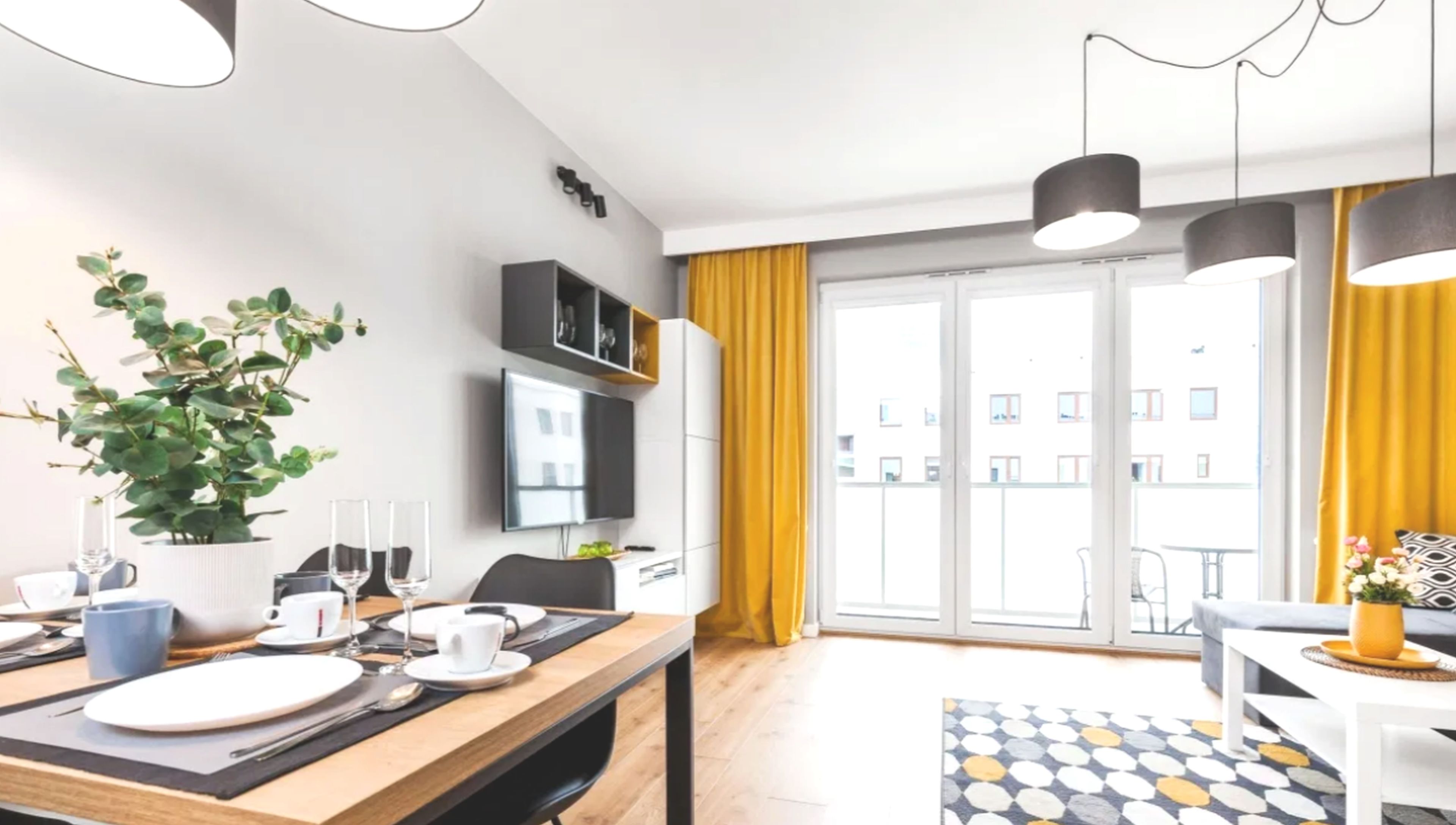 Una sala de estar moderna con comedor, ventanas amplias y vista a edificios.