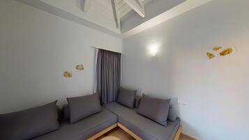 Una sala de estar moderna con un sofá modular, un ventilador de techo y una ventana con cortinas.