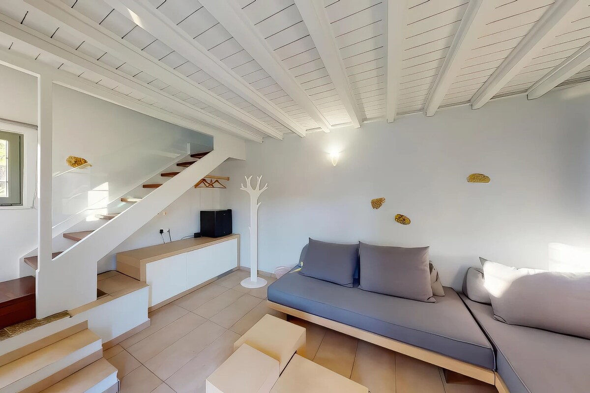 A modern interior with a staircase, a sofa, and a white ceiling.
