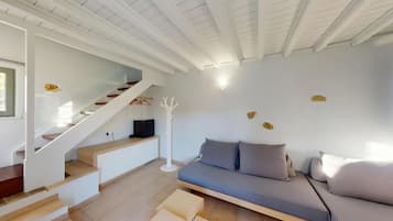 A modern interior with a staircase, a sofa, and a white ceiling.