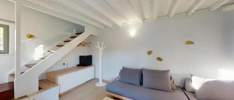 Un interior moderno con una escalera, un sofá y un techo blanco.