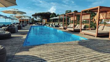 A poolside area with lounge chairs and umbrellas.