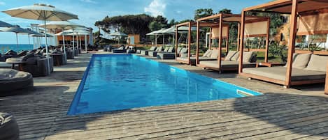 A poolside area with lounge chairs and umbrellas.