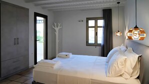 Un dormitorio con cama, armario, ventana y puerta.
