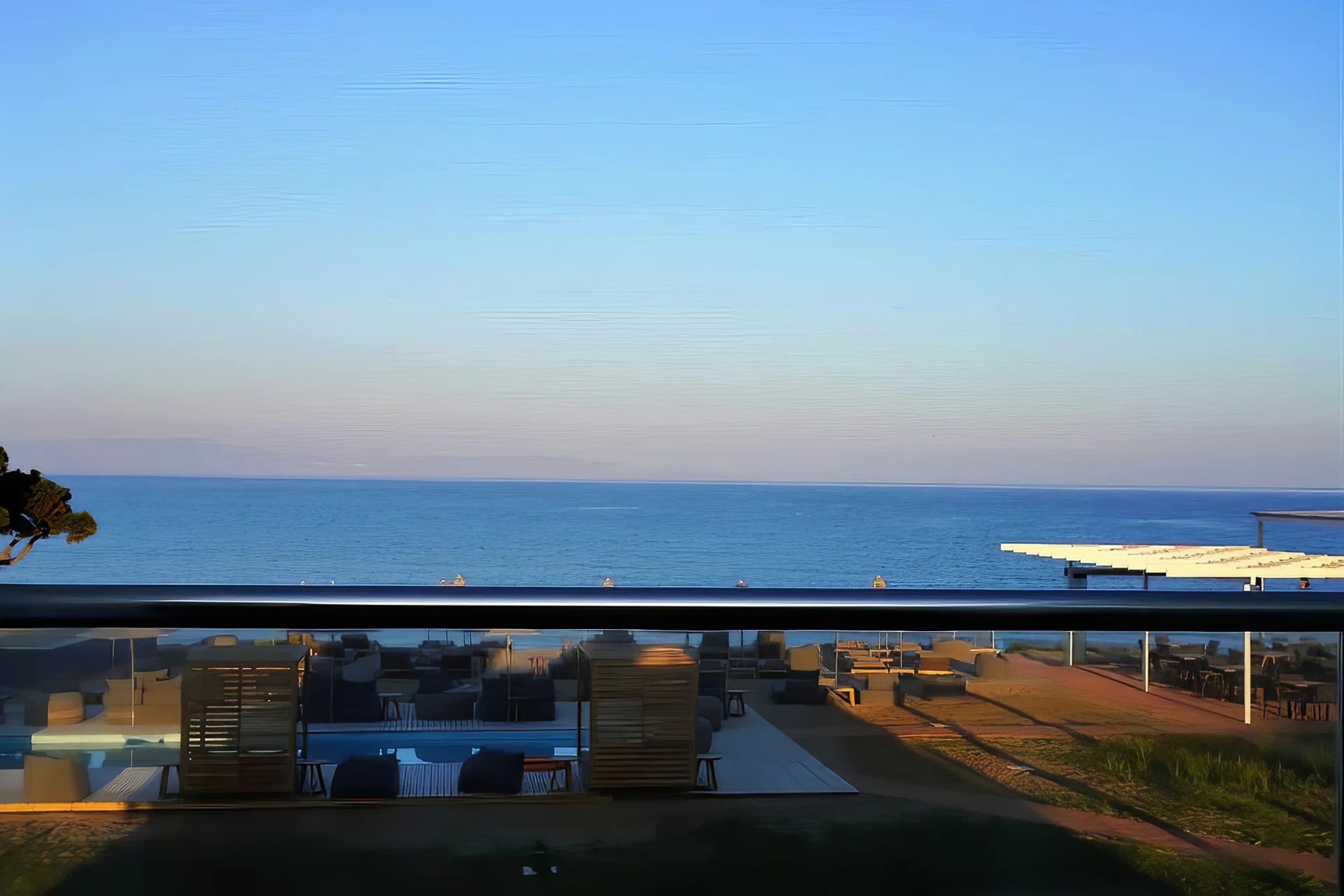 Ein Balkon mit Meerblick, Sitzgelegenheiten im Freien und ein Poolbereich.
