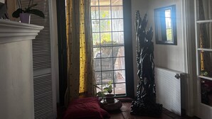 A room with a large window, a radiator, a potted plant, and a ceiling light fixture. - Luxury Villa with All Amenities in Marbella – Pool, Jacuzzi, Barbecue, Wood-Fired Oven (Benahavís)