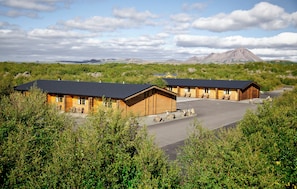 A lodge with multiple cabins, a paved driveway, and a mountainous backdrop.