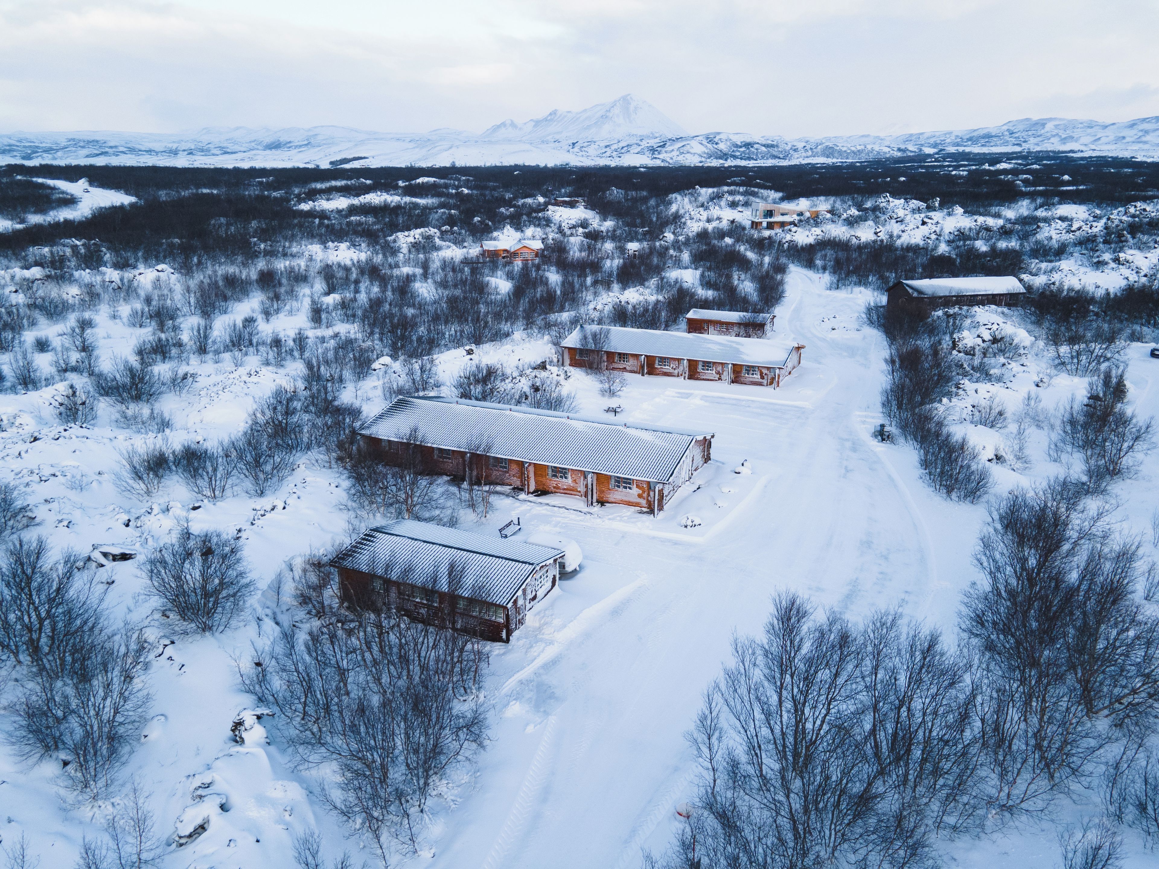 A snow-covered landscape with several wooden cabins.