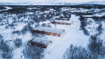 A snow-covered landscape with several wooden cabins.