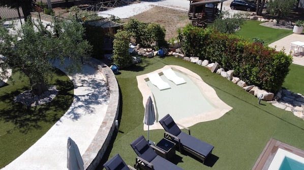 A backyard with a swimming pool, lounge chairs, and a small deck area. - La Linea Dell Orizzonte (Martina Franca)