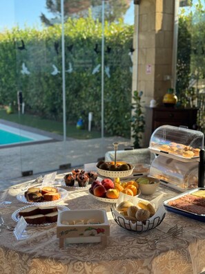 Un buffet en plein air proposant une variété de plats, avec une piscine en arrière-plan.