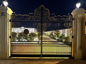 A gated entrance with ornate metalwork and a sign with a sun emblem. - Rambagh Resorts By Stotrak, Gwalior (Gwalior)