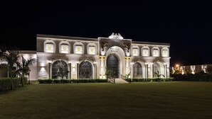 Um edifício grande e iluminado, com janelas em arco e uma entrada central.