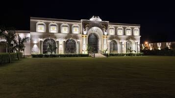 A large, illuminated building with arched windows and a central entrance.