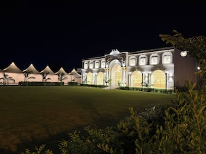 A grand hotel with a symmetrical facade, large arched windows, and a well-lit entrance. - Rambagh Resorts By Stotrak, Gwalior (Gwalior)