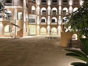 A courtyard with a spiral staircase, a large central door, and a decorative metal sculpture. - Rambagh Resorts By Stotrak, Gwalior (Gwalior)