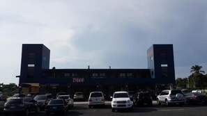 A hotel with a prominent 'HOTEL' sign, multiple parking spaces, and a clear sky. - Express Inn Coronado & Camping (Nueva Gorgona)
