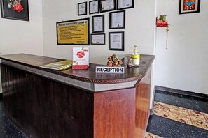 A reception desk with a sign reading 'RECEPTION,' framed certificates on the wall, and a 'What's on your mind?' feedback box. - Hotel O Motel Langko (Mataram)