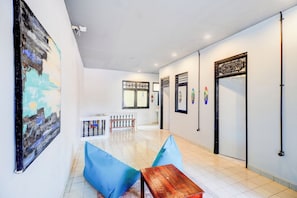 A hallway with a bench, a table, and a painting on the wall.