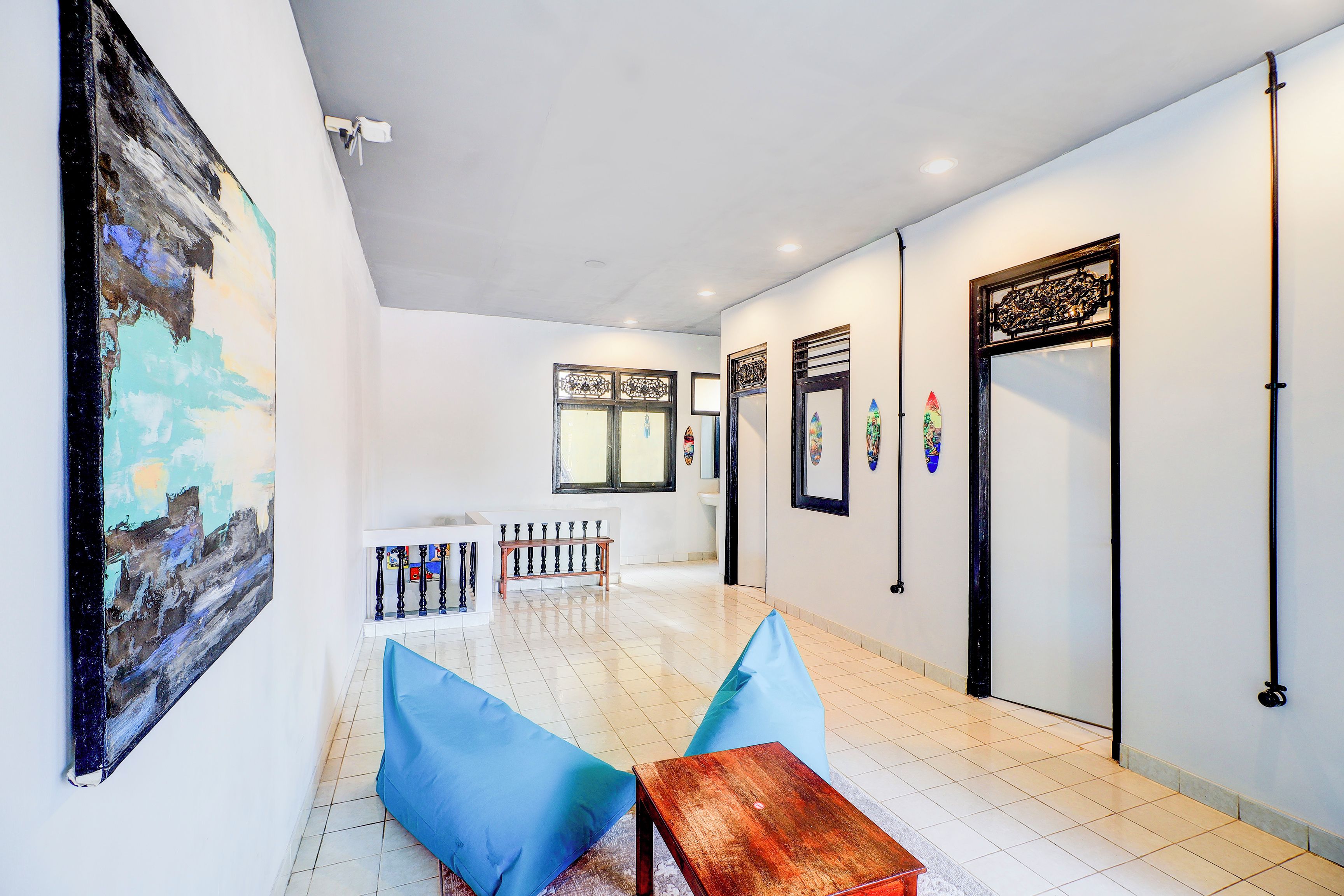 A hallway with a bench, a table, and a painting on the wall.
