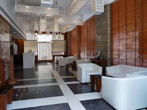 A hotel lobby with a reception desk, seating area, and decorative lighting. - Hotel Coral Star (Chandigarh)