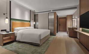 A modern hotel room with a large bed, bedside tables, a flat-screen TV, and a walk-in closet. - Doubletree by Hilton Zhengzhou East (Zhengzhou)