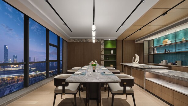Un comedor moderno con vistas a la ciudad, una mesa de mármol y muebles contemporáneos.