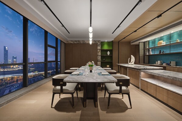 A modern dining area with a city view, a marble table, and contemporary furnishings. - Doubletree by Hilton Zhengzhou East (Zhengzhou)