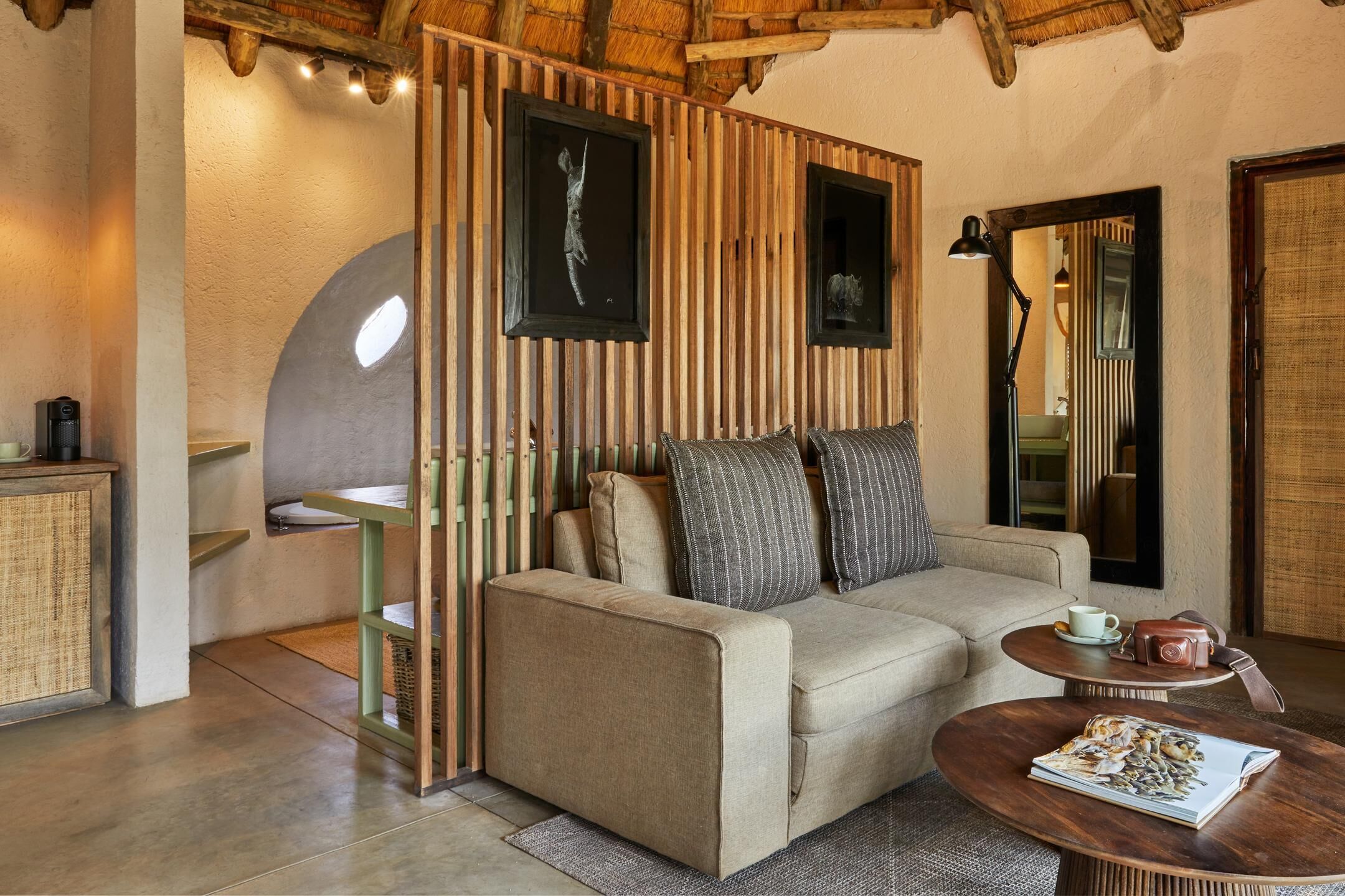 Une pièce chaleureuse avec un canapé, une petite table, un meuble et un mur recouvert de lambris en bois verticaux.