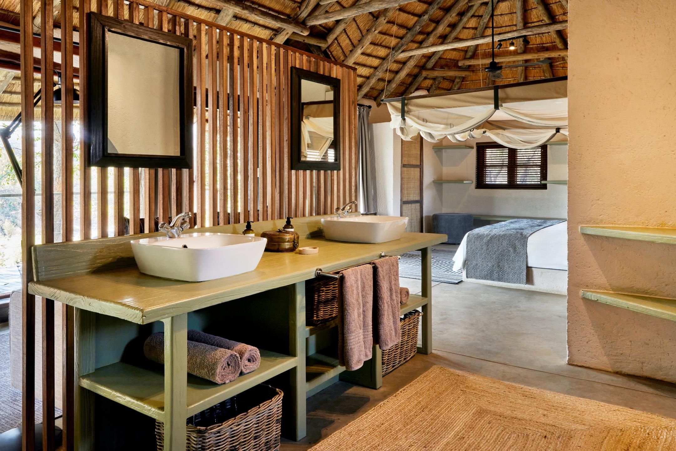 A bathroom with two sinks, a mirror, and a wooden vanity.