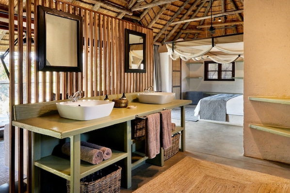 Un baño con dos lavamanos, un espejo y un mueble de tocador de madera.